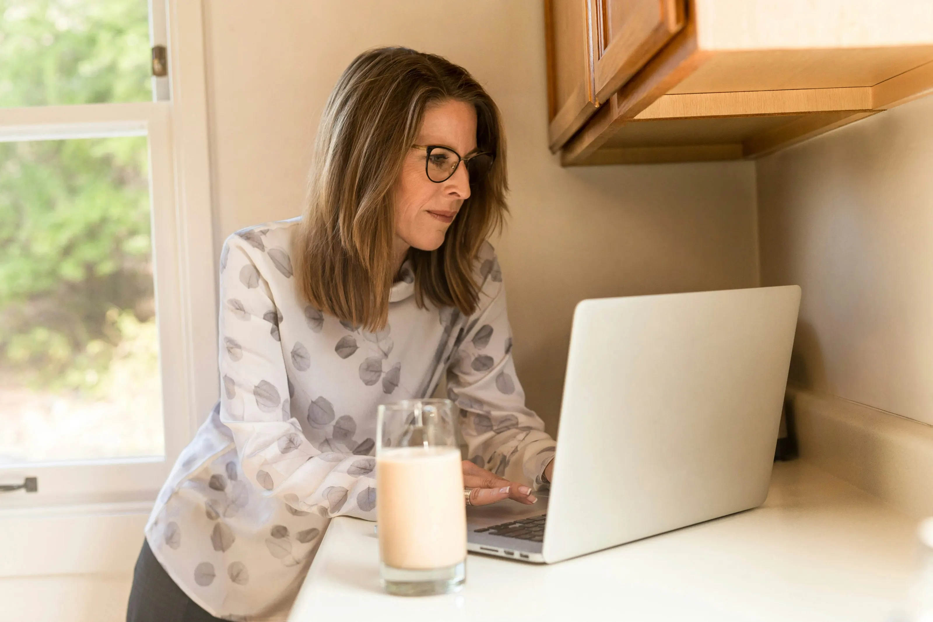 A woman completing her health assessment on a laptop at home