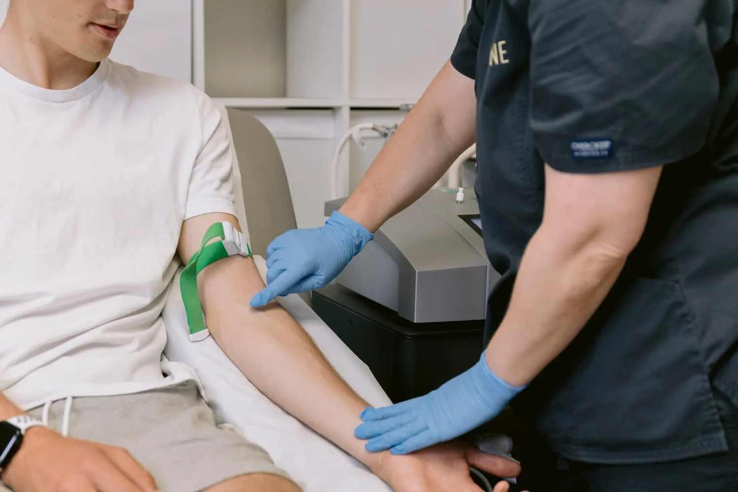 A practitioner at The Ozone Clinic preparing a man's arm for a blood draw