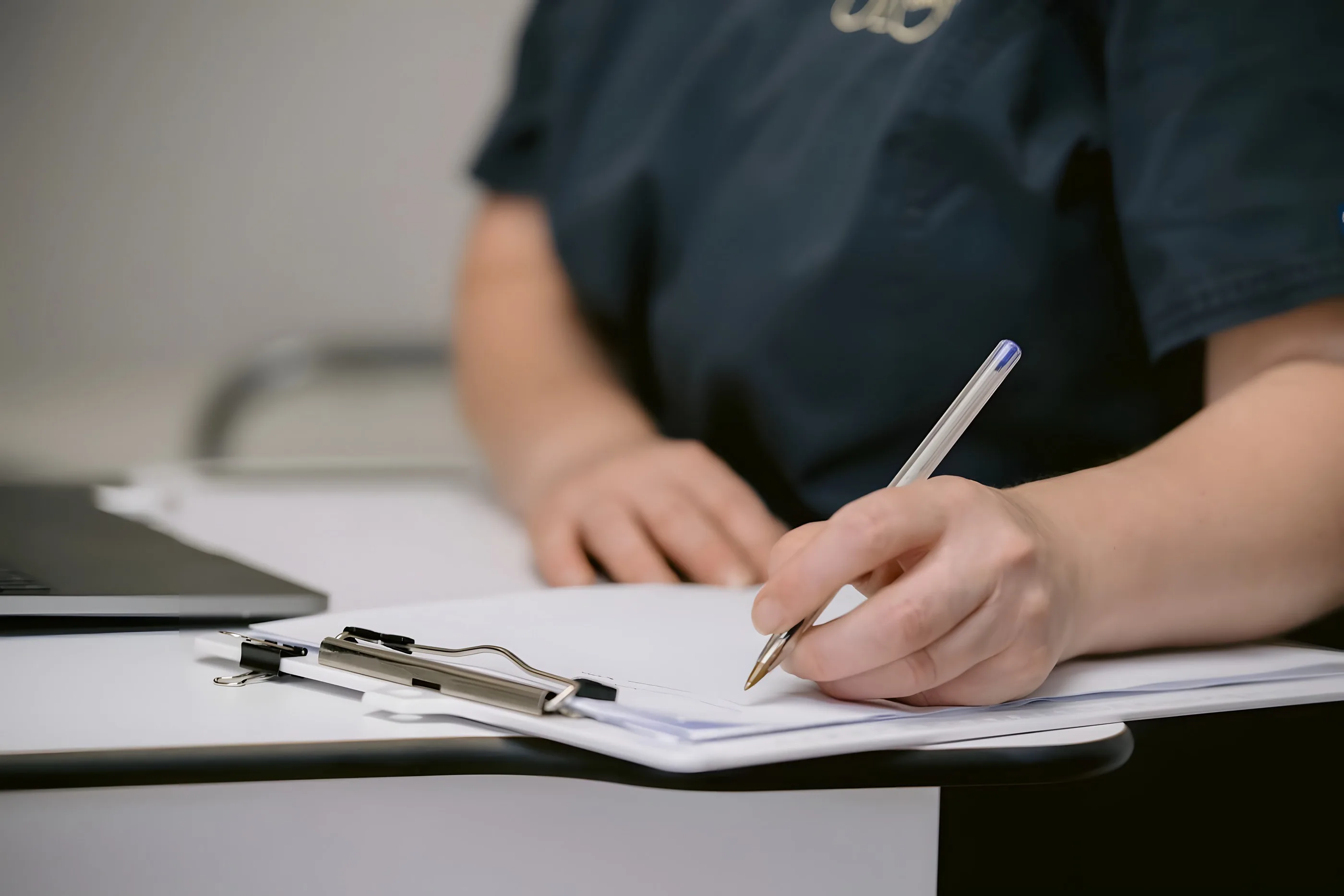 A practitioner making notes during a consultation