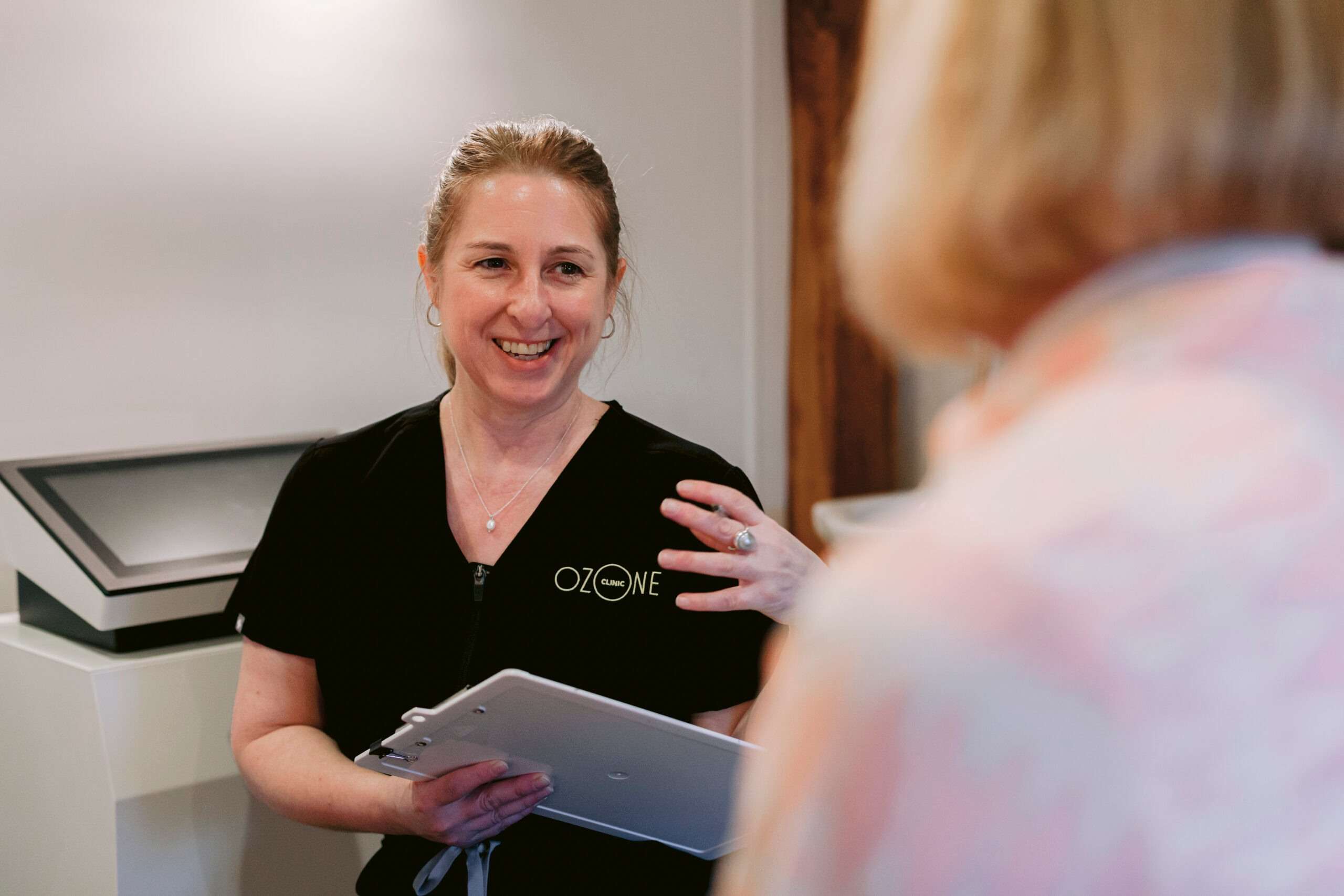 Laura Dinham talking through health information with a client at The Ozone Clinic